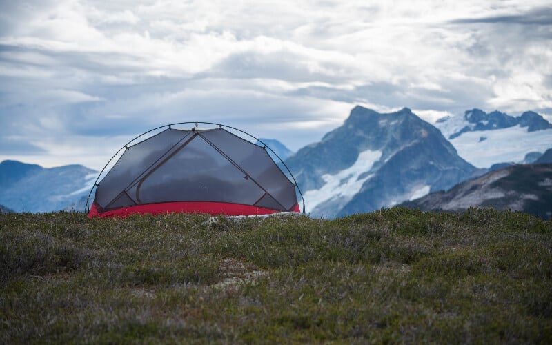 A bug-proof tent in front of a mountain.