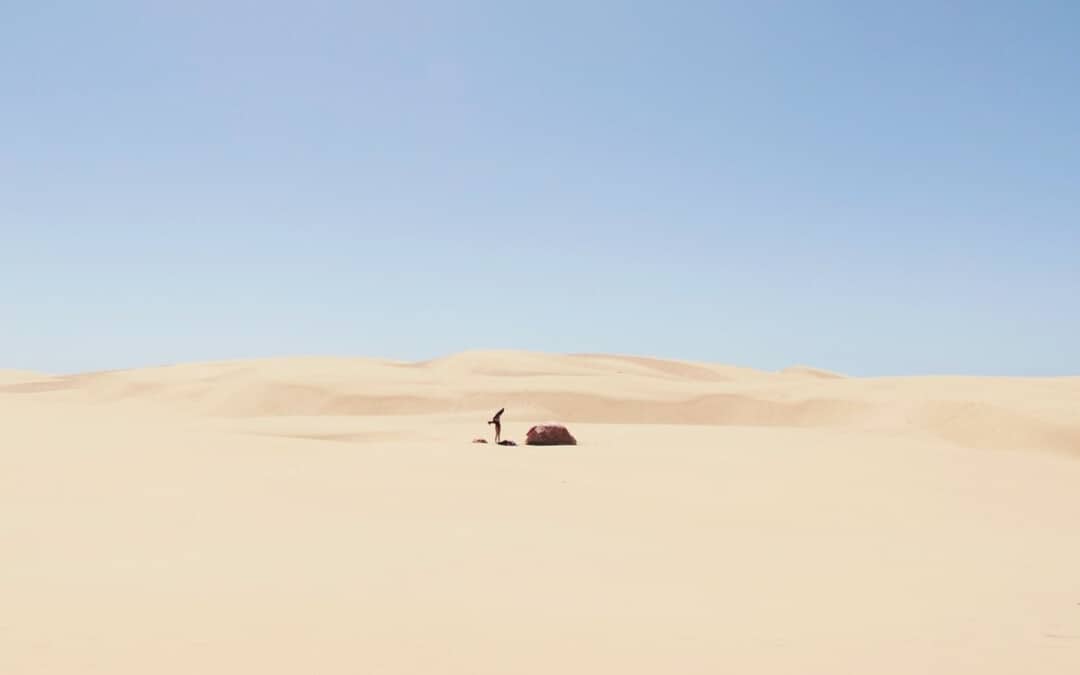 A picture of a person with a tent in a desert camping in hot weather.