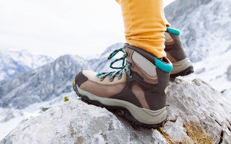 Close up of a woman's hiking boots on a mountain trail.