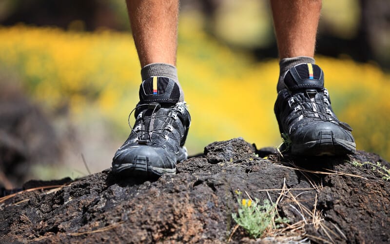 Close up of a man's hiking shoes on a rock.